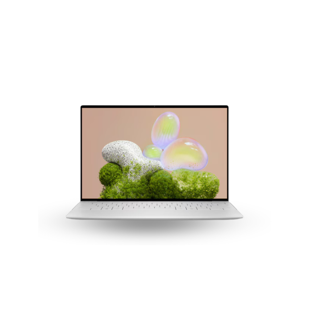 A silver Dell XPS 13 laptop is shown open and facing directly forward on a white background. The screen displays the Windows 11 desktop with the Start Menu open, showing various application icons. The keyboard and trackpad are also silver, matching the laptop's body.